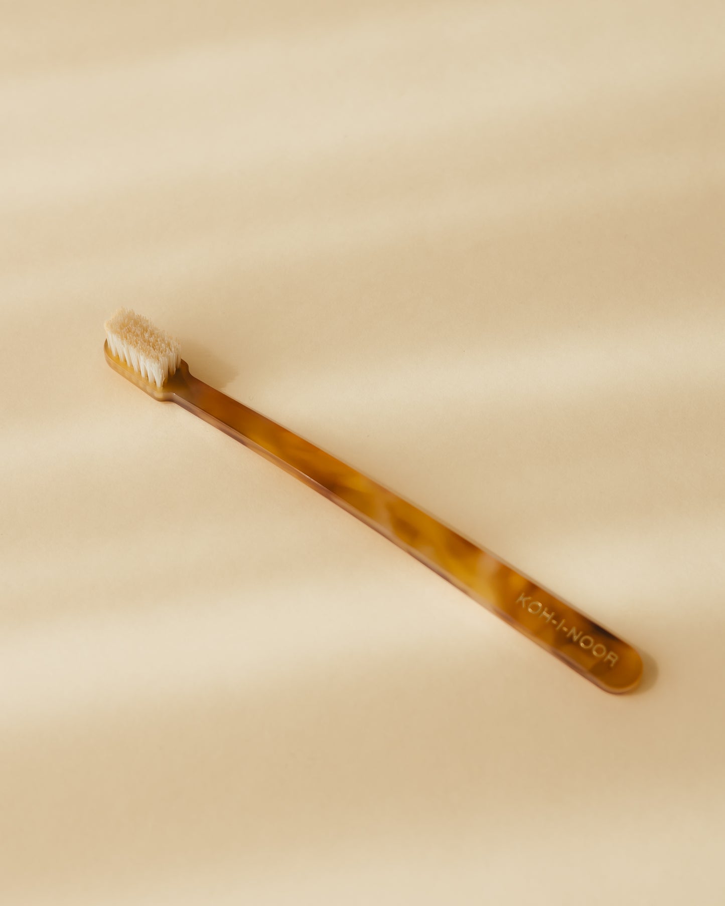A Koh-i-Noor coccola toothbrush in honey yellow colour, cellulose acetate.