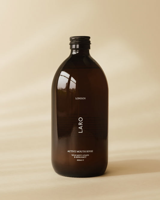 Brown bottle of Laro Active Mouth Rinse on a beige background
